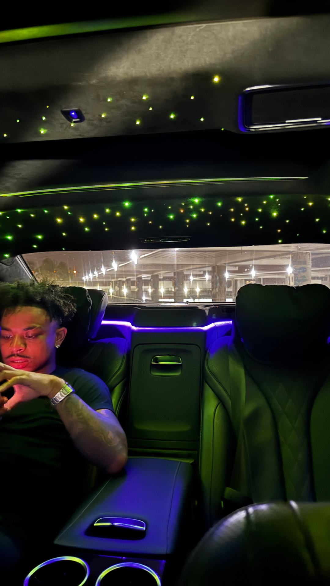 Darrin, founder of DXRRIN, in the back of a luxury car at night